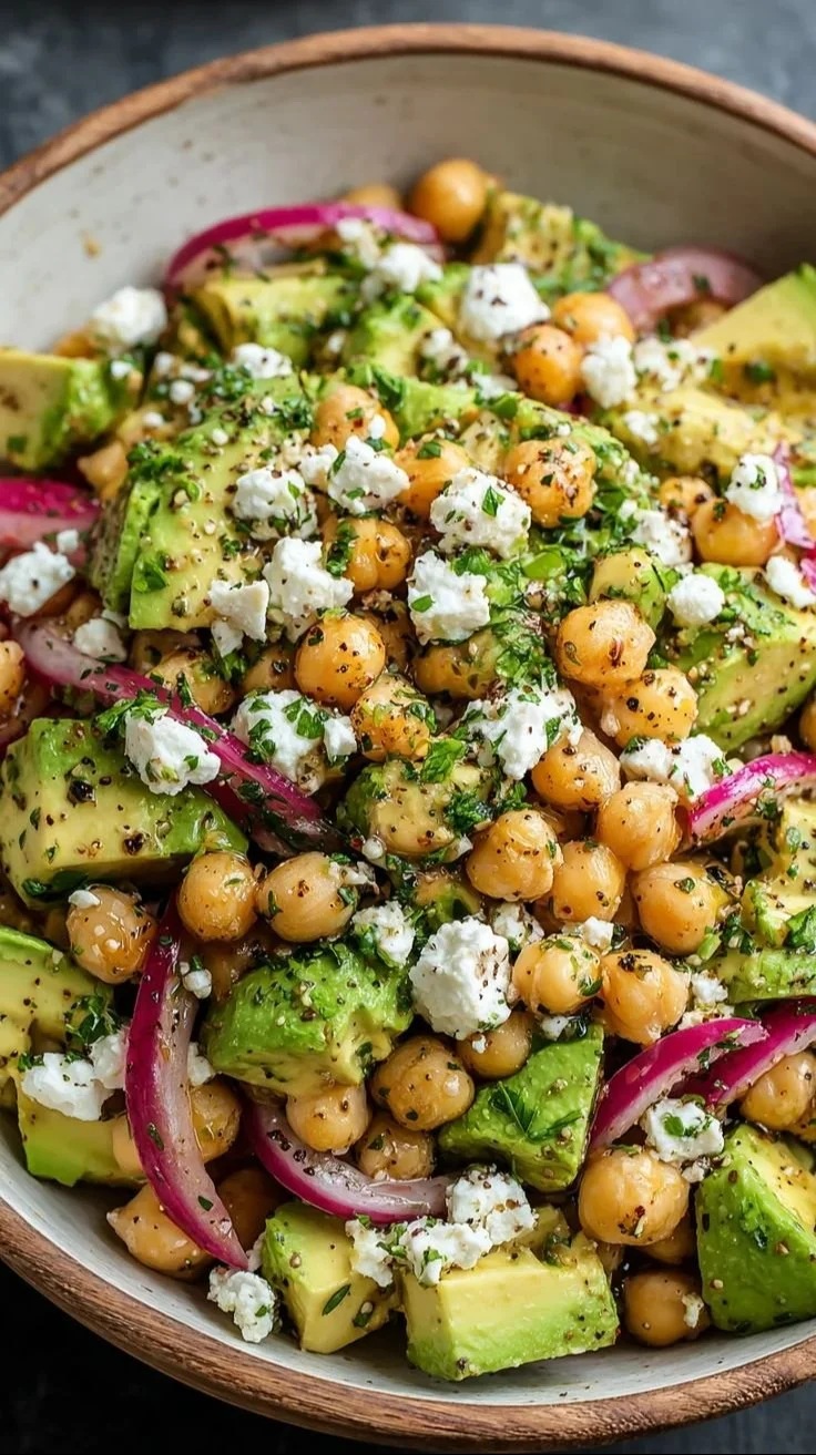 Chickpea salad with feta, avocado, and fresh vegetables in a bowl