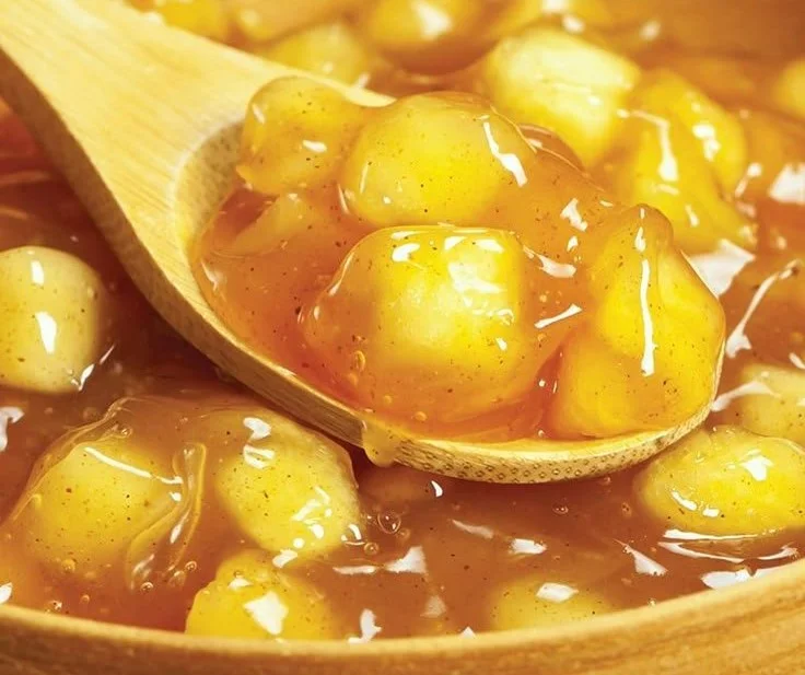 Homemade apple pie filling in a bowl with fresh apples and spices