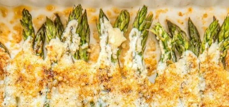 Fresh, green asparagus spears on a wooden cutting board ready for cooking.