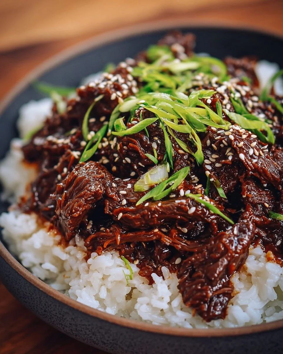 Slow cooked Korean Beef served in a bowl with rice and vegetables.