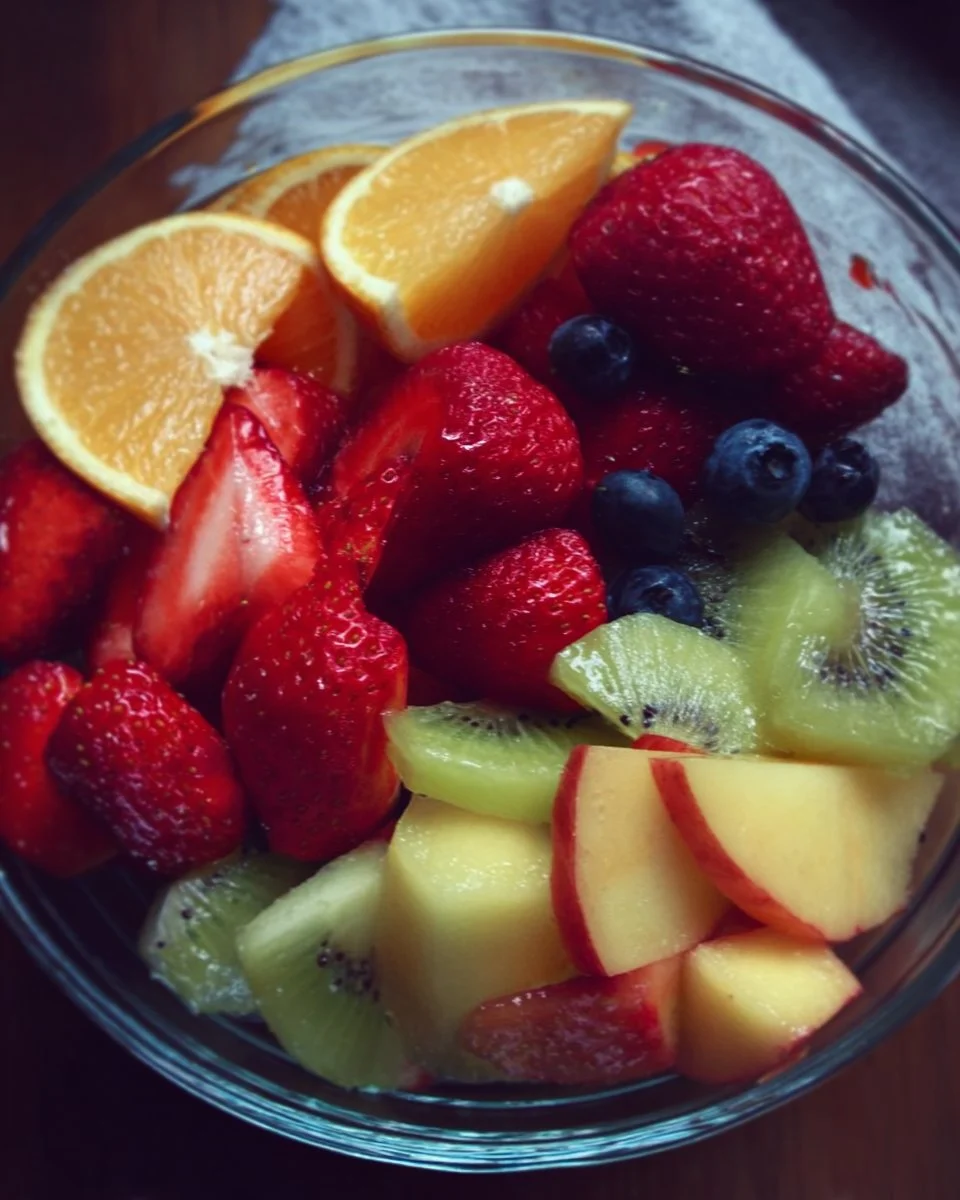 A colorful bowl of fresh fruit salad with a variety of fruits