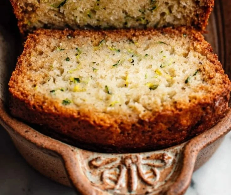 Slice of homemade banana zucchini bread on a wooden table